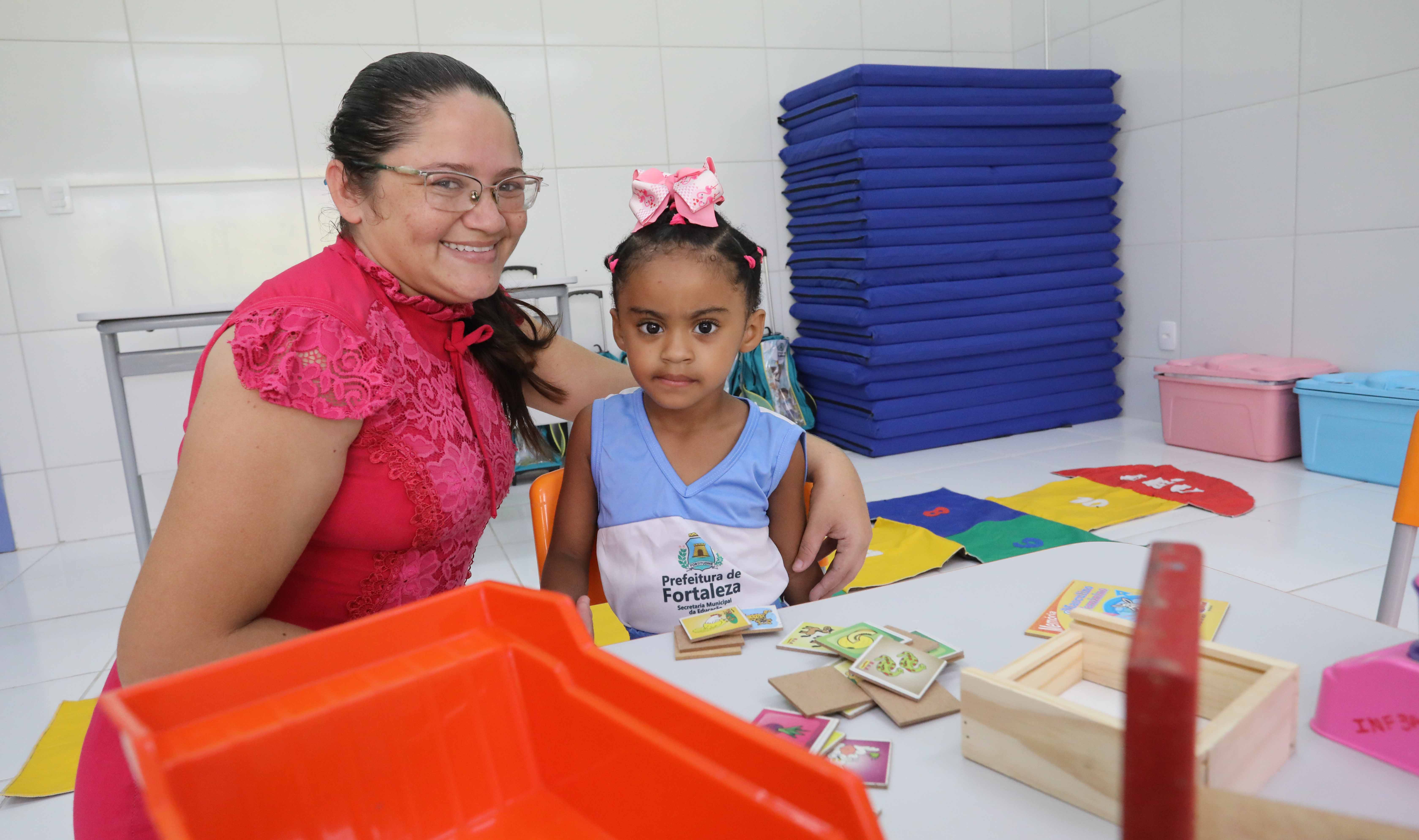 mulher e criança posam para a foto em uma sala de aula